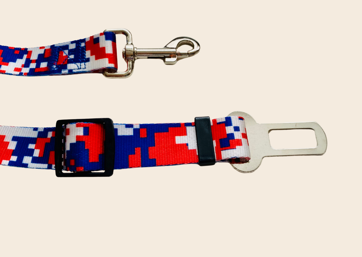Enden eines Autogurtes in grafischen Muster in rot, weiß und blau. Zu sehen in Nahaufnahme die Schnalle und der Karabiner.