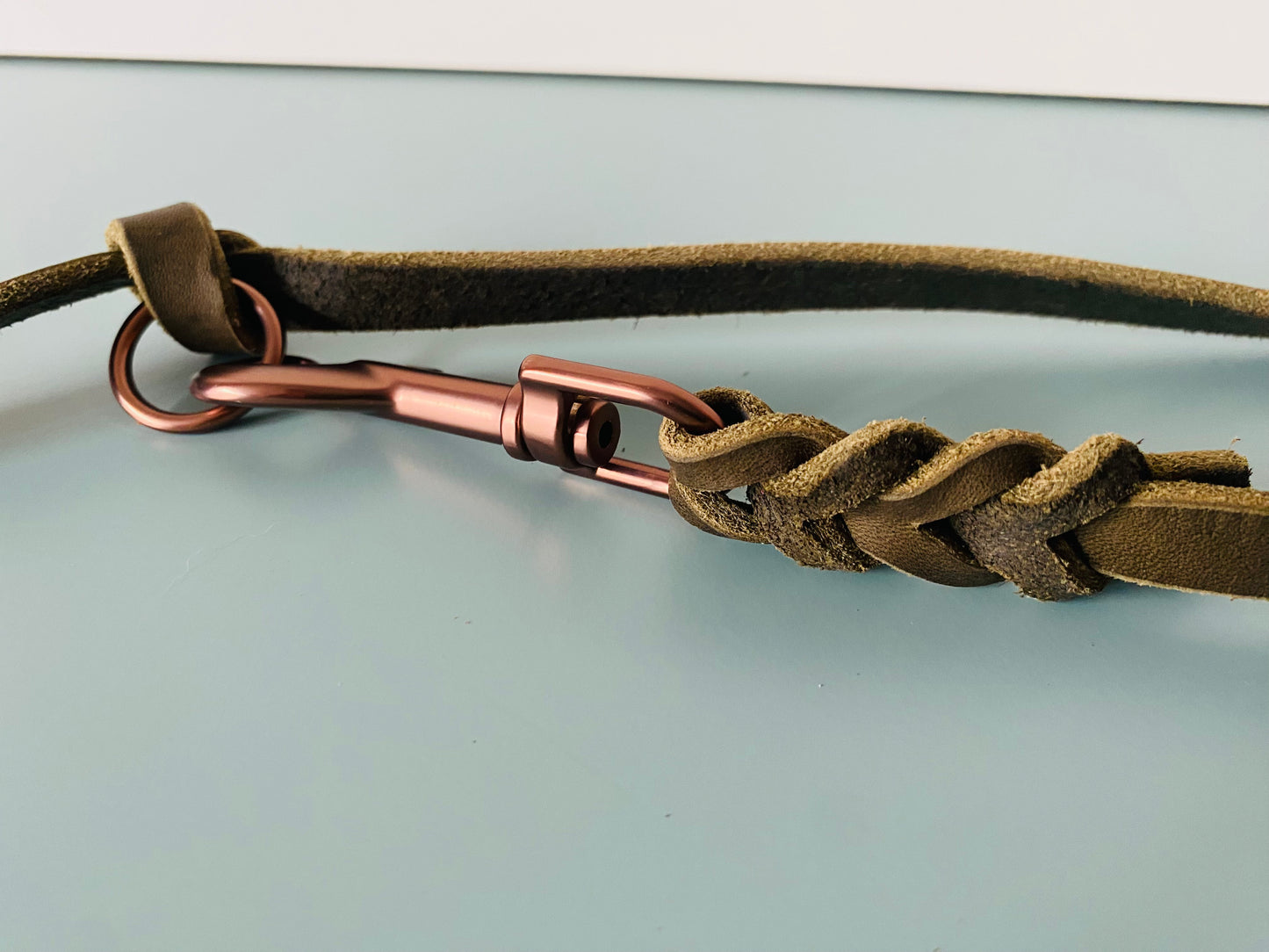 Karabiner in mattem braun , der in Leder eingeflochten ist.
