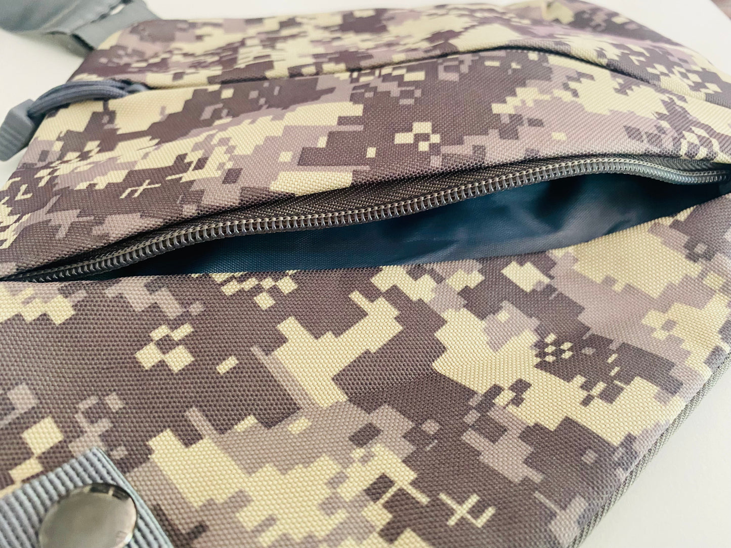Tasche aus Canvas mit geöffnetem Reißverschluß. Das Muster ist Camouflage.
