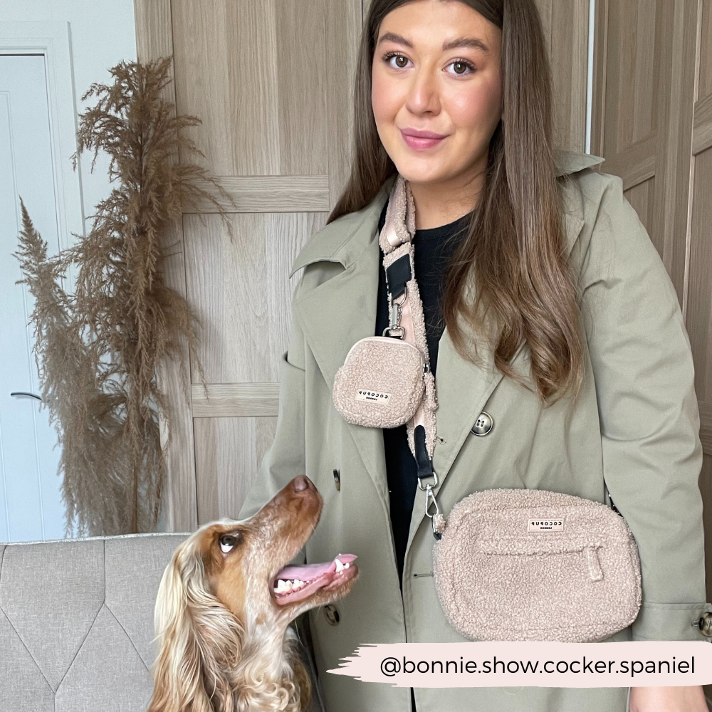 Frau mit dunklen langen Haaren und Hund trägt Tasche aus Teddystoff in beige.