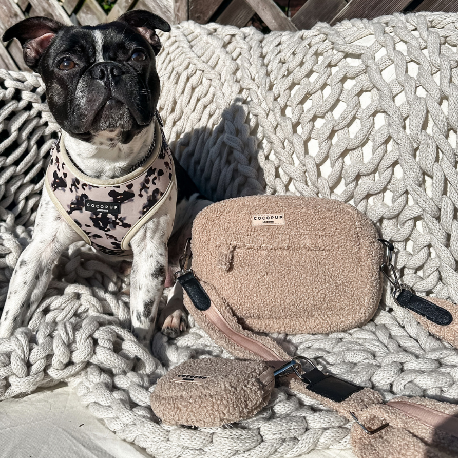 Tasche aus Teddystoff in beige liegt auf einer gehäkelten Decke. daneben ein Boston Terrier mit Geschirr in Tupfenmuster.
