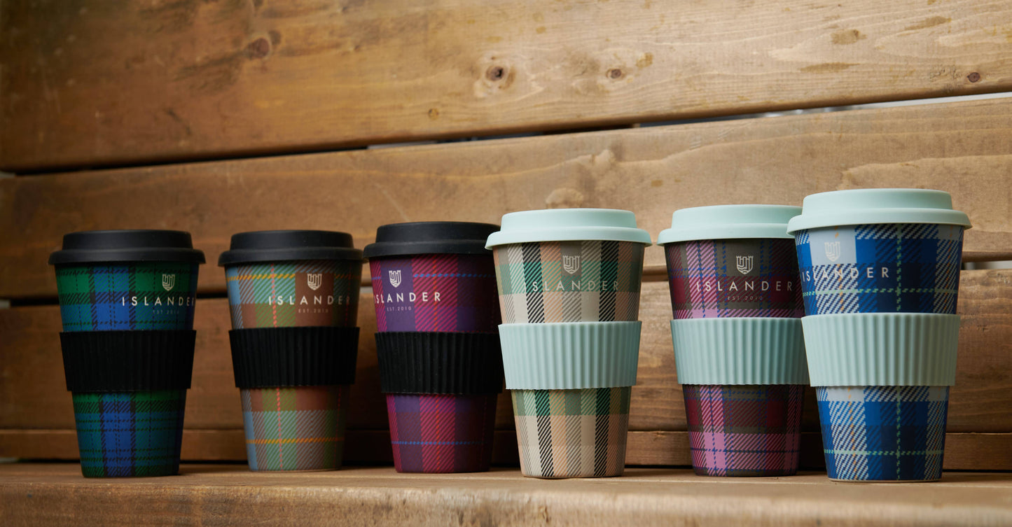 Sechs verschiedene Thermobecher mit Tartanmuster in unterschiedlichen Farben . Die Becher haben einen Deckel und eine Banderole aus Kunststoff.
